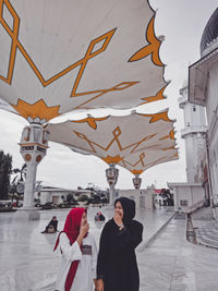 People standing on street amidst buildings in city