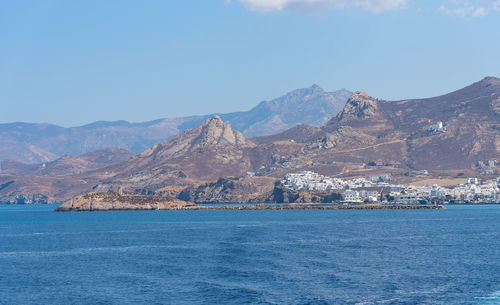 Scenic view of sea and mountains against clear blue sky