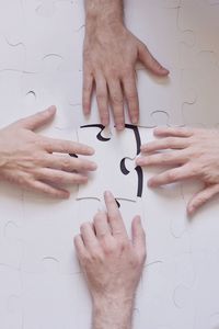 Cropped hands touching jigsaw puzzle