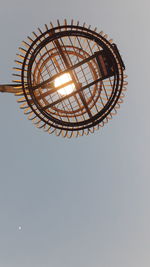 Low angle view of illuminated electric lamp against sky