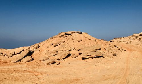 Scenic view of desert against clear blue sky