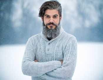 Portrait of young man standing in snow