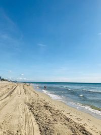 Scenic view of beach against blue sky