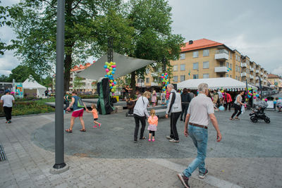 People at town square against sky in city