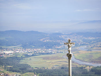 Statue of cross on mountain against sky