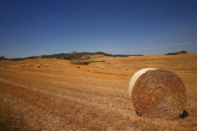 Hay bales on field against sky