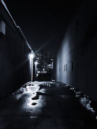 Illuminated road amidst buildings in city at night