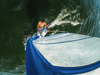 Wide-angle shot of adult man windsurfing on lake wallersee, austria