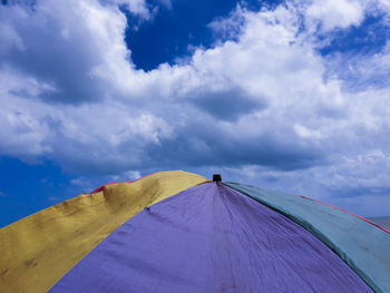 Low angle view of tent against cloudy sky
