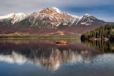Scenic view of lake by mountains against sky