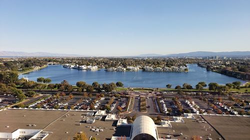 Aerial view of parking lot by river against cityscape