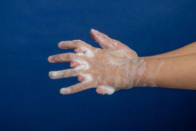 Close-up of hand against blue background