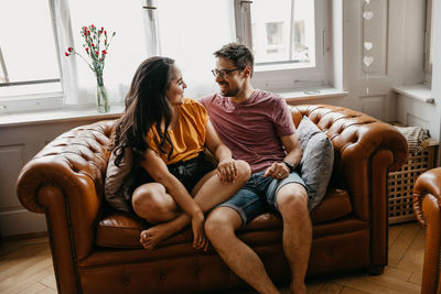 Young couple sitting on sofa at home