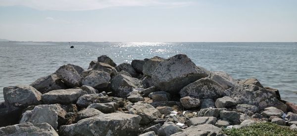 Rocks by sea against sky