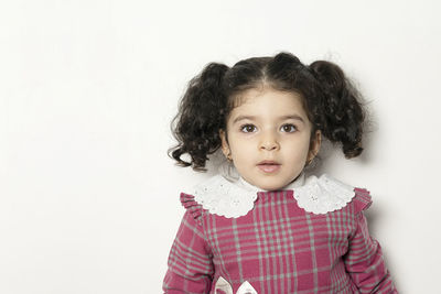 Portrait of cute girl standing against white background