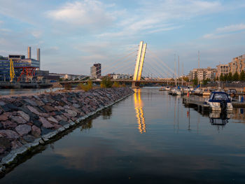 Sailboats in river against sky in city