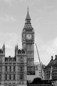 Big ben and buildings against cloudy sky