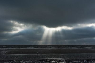 Scenic view of sea against storm clouds