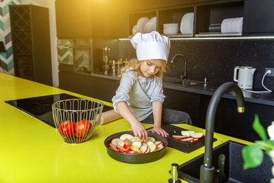 Rear view of woman preparing food at home