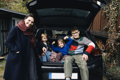 Happy family with electric car enjoying together in back yard