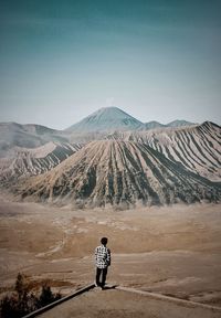 Rear view of man standing against mountain