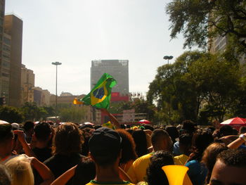 People on street in city against sky