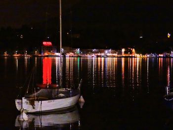 Boats in calm lake at night