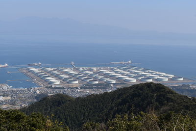 High angle view of agricultural field by sea against sky