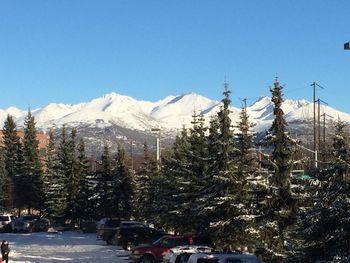 Scenic view of snow covered mountains against blue sky