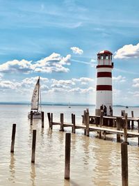 Wooden posts on pier over sea against sky