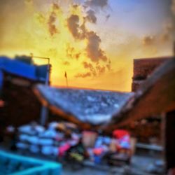 Crowd in city against sky during sunset