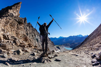 Rear view of man on rock against sky