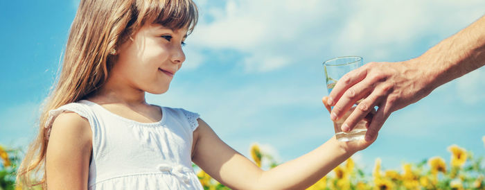 Cropped hand of father giving water glass