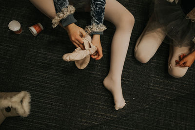 Overhead shot of child putting on ballet slipper