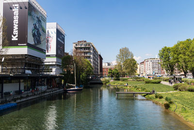 River amidst buildings in city against clear sky