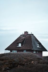 House on field against clear sky