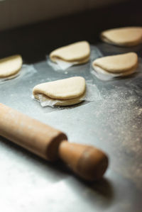 Rolling pin and flour for making fresh baos over a steel countertop.