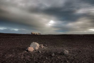 Scenic view of field against storm clouds