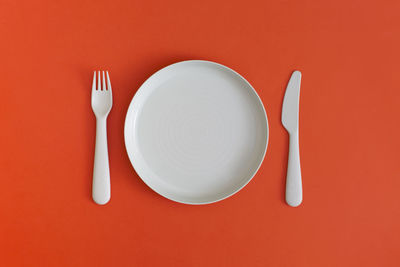 Directly above shot of empty plate on yellow background