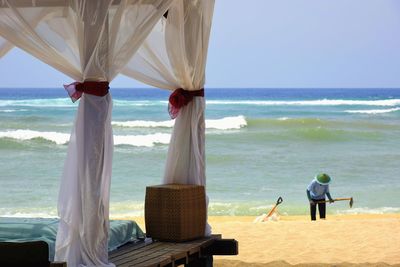 Rear view of people relaxing on beach