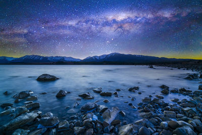 Scenic view of lake against sky at night