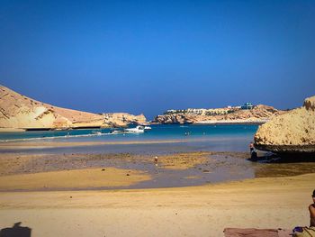 Scenic view of beach against clear blue sky