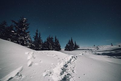 Scenic view of snow covered landscape against clear sky at night