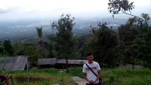 Full length portrait of young man sitting on land