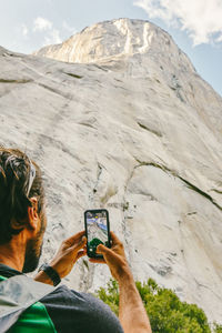 Young man taking picture of el capitan mountain in yosemite park.