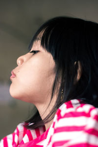 Close-up side view of girl looking away at home