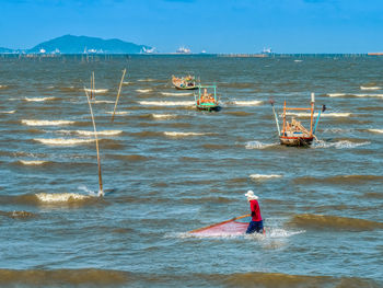 Man surfing in sea against sky