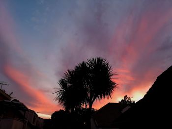 Low angle view of silhouette palm tree against romantic sky
