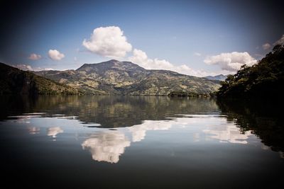 Scenic view of lake by mountains against sky