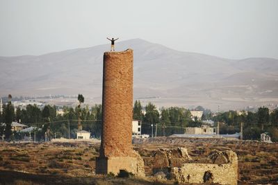 Young man standing on fort against clear sky